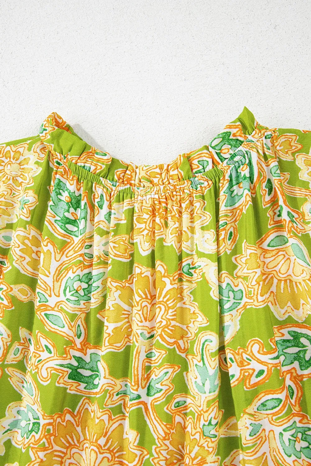 Women's blouse with patchwork design, bubble sleeves, and cheerful print.